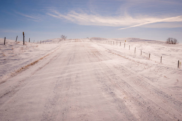 Nieve soplando sobre la carretera de grava en un invierno Saskatchewan
 - Foto, imagen