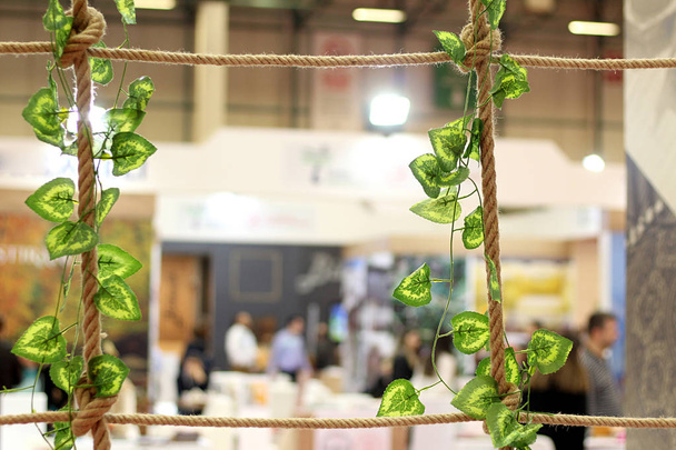 Frame and frame of brown rope and green leaves tied together at an exhibition crowded - Photo, Image