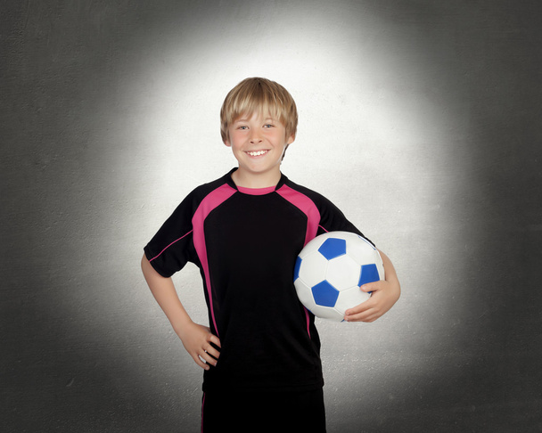 Preteen with a uniform for play soccer holding a ball - 写真・画像