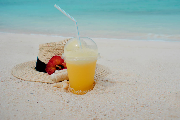 Tropik bir adada dinlenmek kavramı. Koruma güneş ve ısı. Hasır şapka ve ananas suyu - Fotoğraf, Görsel