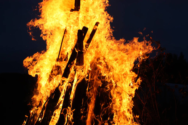 Яскраве полум'я багаття на сільському полі ввечері
 - Фото, зображення