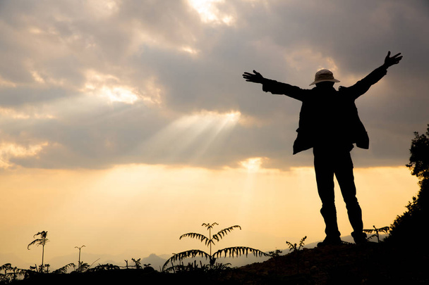 キリスト教の概念の信仰: 精神的な祈り手ぼかし美しい夕日を背景に太陽の輝き - 写真・画像