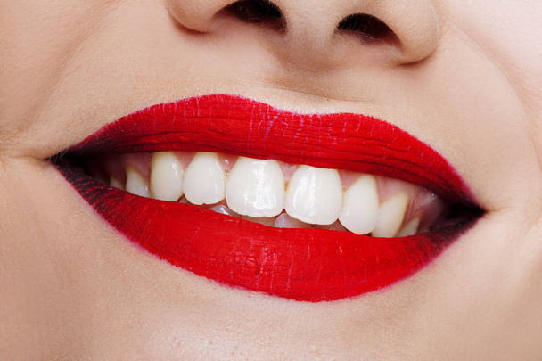 Hermosos labios de mujer con lápiz labial rojo brillante y dientes blancos
. - Foto, Imagen
