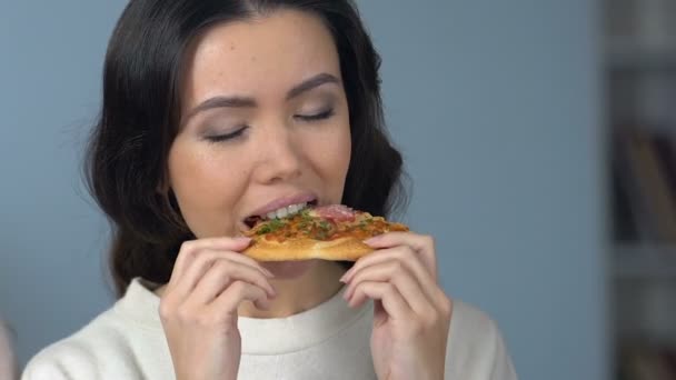 Ξανθιά κοπέλα προτιμώντας ζουμερός μήλο να σκουπίδια πίτσα σε αντίθεση με το φίλο της Ασίας, τρώγοντας - Πλάνα, βίντεο