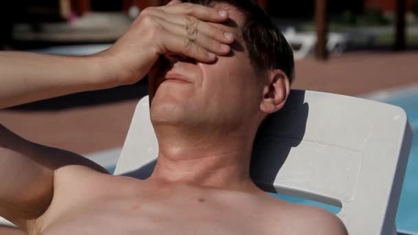 człowiek z nagi tors, leżącego na słońcu krzesła i zamyka oczy czarne okulary - Materiał filmowy, wideo