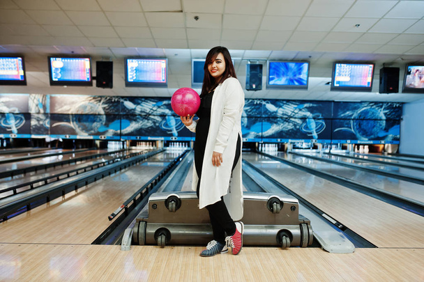 Stylish asian woman standing at bowling alley with ball at hand. - Foto, Imagen