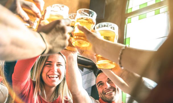 Amigos bebiendo y brindando cerveza en el restaurante del bar de la cervecería - Concepto de amistad entre jóvenes millenials divirtiéndose juntos en la hora feliz en el pub de cerveza - Enfoque en la cara de chica - Filtro de sol de verano
 - Foto, imagen