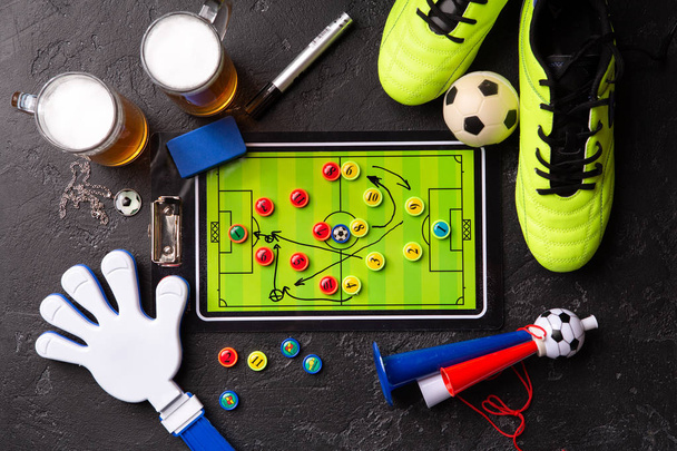発泡ビール、テーブル サッカー、ボール、サッカーのブーツ、パイプ、ガラガラおもちゃの 2 つのマグカップの上に写真 - 写真・画像