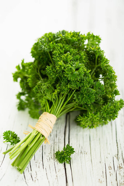 close up view of fresh parsley on wooden tabletop - Фото, зображення