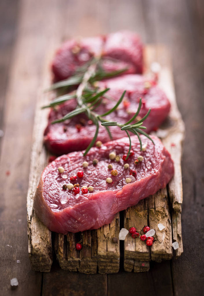 close up view of raw meat with spices ready for cooking on wooden tabletop - Fotografie, Obrázek