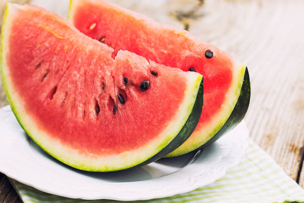 close up view of fresh ripe watermelons on wooden table - Photo, image