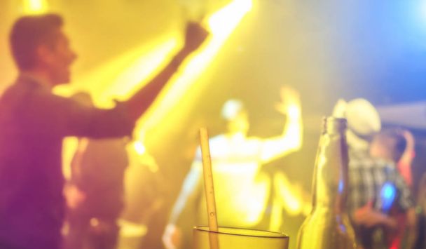 Des gens flous déconcentrés dansent lors d'un festival de nuit de musique - Image abstraite du club disco après la fête avec un spectacle laser - Concept de divertissement de la vie nocturne - Filtre à lumière spot multicolore
 - Photo, image