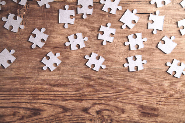 Pieces of the jigsaw puzzles on wooden background.  - 写真・画像