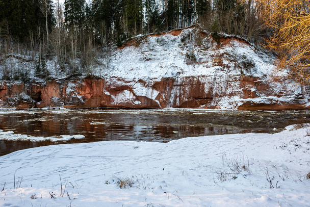 fagyasztott erdő folyó télen a homokkő sziklák, hó és jég, süt a nap - Fotó, kép