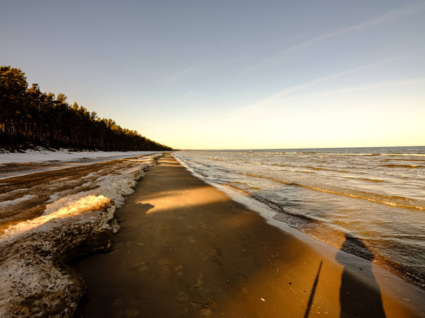 blocs de glace gelés sur la plage de la mer en hiver avec du sable et de la neige par temps couvert
 - Photo, image
