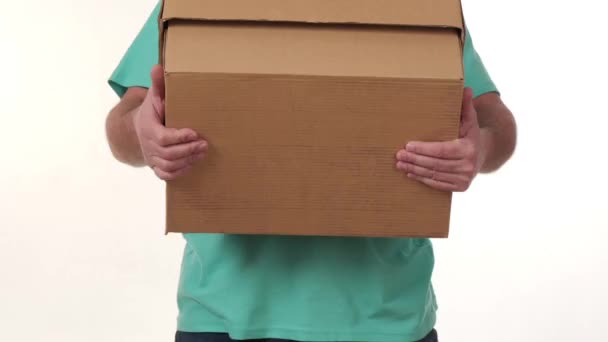 muž drží ve svých rukou velkou krabici na bílém pozadí. - Záběry, video
