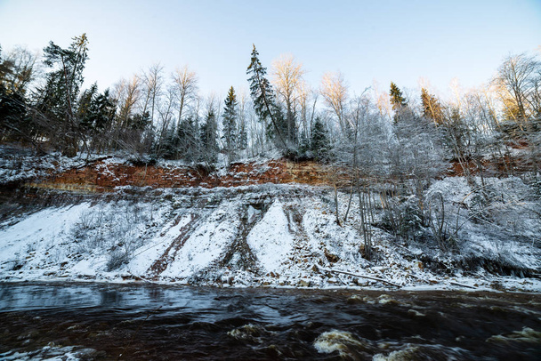 Orman nehir kumtaşı kayalıklarla, kar ve buz güneşli gün ile kışın donmuş - Fotoğraf, Görsel