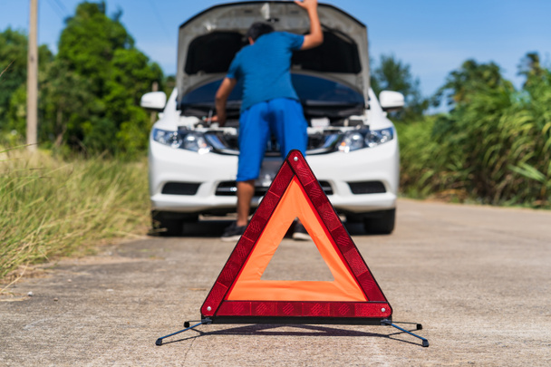 Мужчина и красный знак аварийной остановки и проблема с белой машиной на дороге
 - Фото, изображение