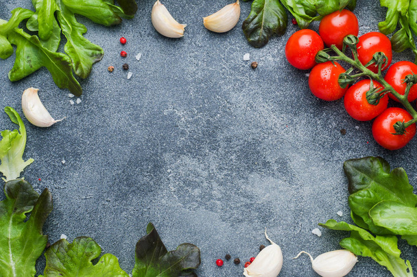 Cherry tomatoes on a branch Fresh herbs and garlic clove with spices on a dark stone table Top view with copy space - Photo, Image