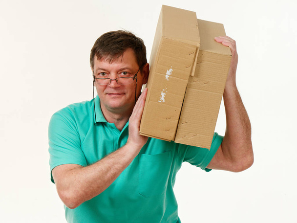 man houdt in zijn handen een grote doos op een witte achtergrond 5 - Foto, afbeelding