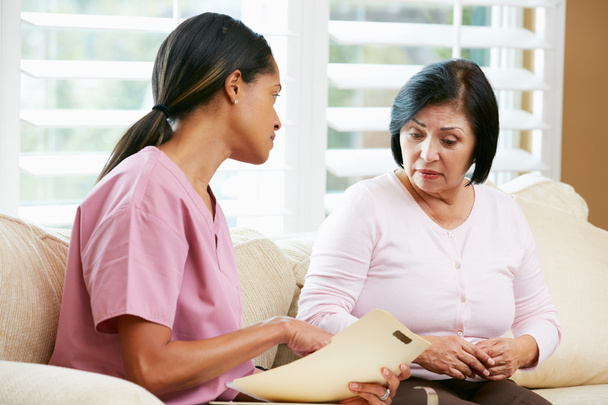 Nurse Discussing Records With Senior Female Patient During Home - Foto, immagini