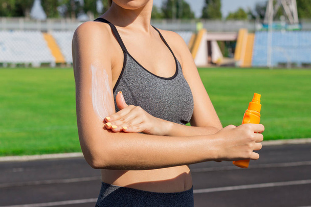 Donna che spruzza crema solare sulla pelle prima di correre. Sport e concetto sano
. - Foto, immagini