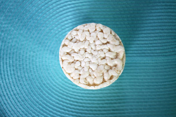 Galletas de arroz redondas planas blancas sobre fondo azul
. - Foto, imagen