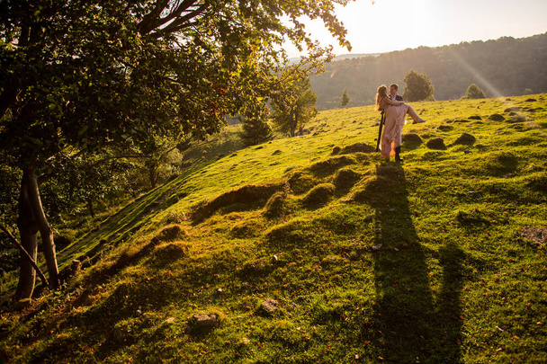 Beautiful wedding couple posing on green hills - Zdjęcie, obraz
