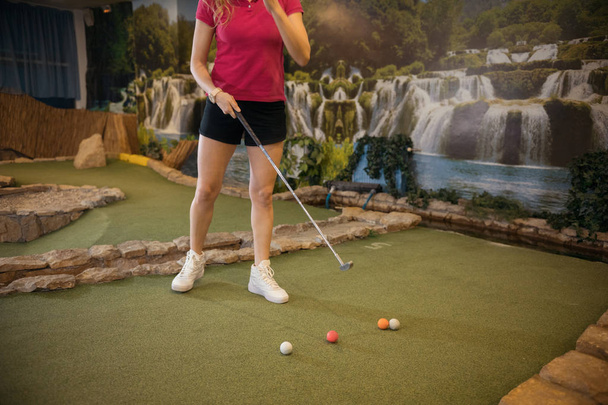 Mladá žena uvnitř mini golfu - Fotografie, Obrázek