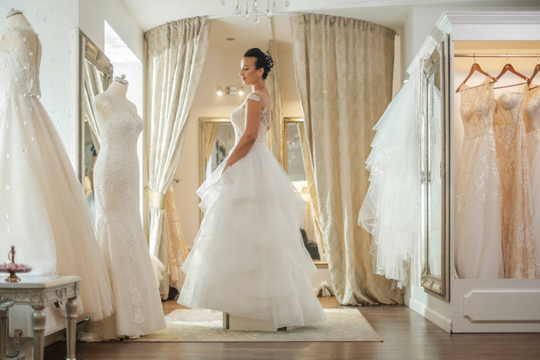 Beautifu novia elegir vestido de novia en un salón de bodas
 - Foto, Imagen