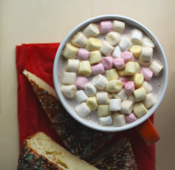 Bebida de cacao con malvaviscos y trozos de pastel casero dulce en una bandeja de madera
 - Foto, Imagen