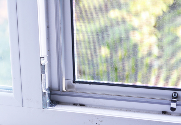 Primer plano en la instalación de la pantalla de alambre de mosquito en la ventana para proteger de los insectos
. - Foto, Imagen