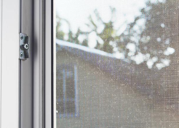 Pantalla de alambre de mosquito en la ventana de la casa para proteger contra insectos
. - Foto, Imagen