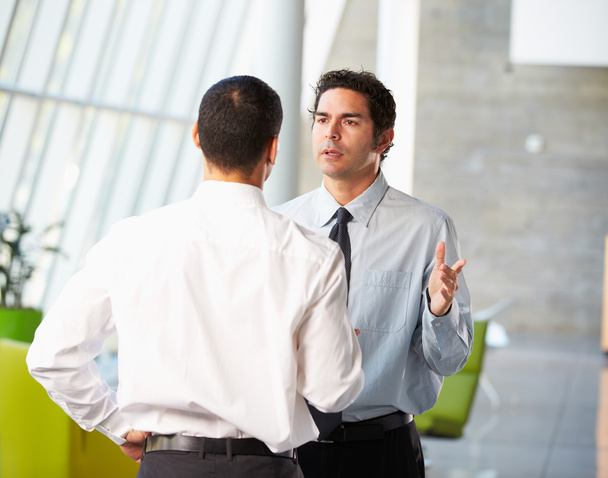 Two Businessmen Having Informal Meeting In Modern Office - Фото, изображение