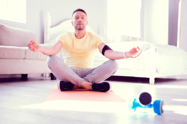 Bearded mature man sitting in lotus position while meditating in the morning - Foto, Imagem