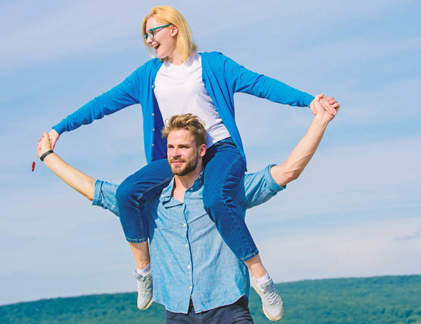 Soulmates enjoy freedom together. Couple happy date having fun together. Freedom concept. Man carries girlfriend on shoulders, sky background. Couple in love enjoy freedom outdoor sunny day - Фото, зображення