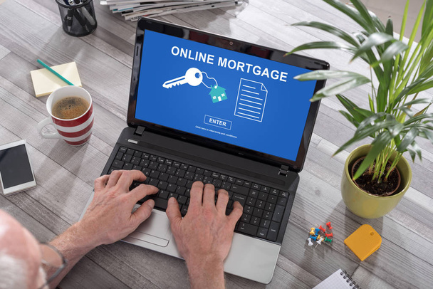Homem usando um laptop com conceito de hipoteca on-line na tela
 - Foto, Imagem