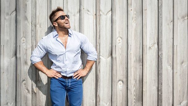 bearded man with sunglasses on wooden wall background  - Foto, afbeelding