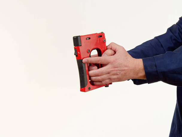 man in overalls holds tool stapler on white background 5 - Photo, Image