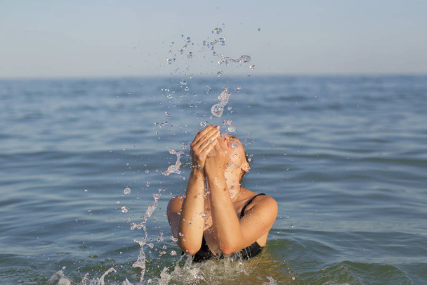 Woman in the sea with splashes of water. - Fotoğraf, Görsel