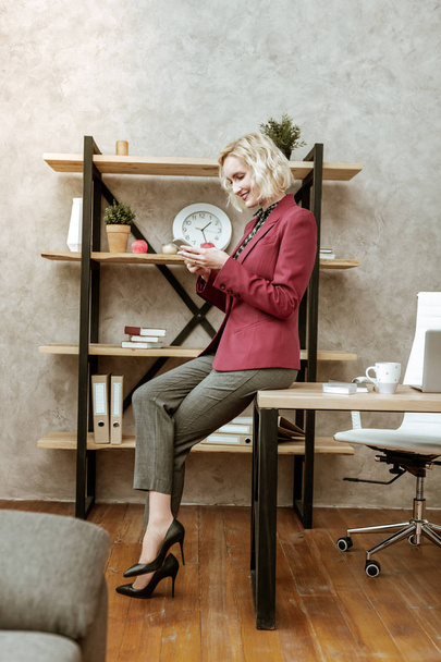 Smiling light-haired businesswoman wearing black high heels - Fotografie, Obrázek