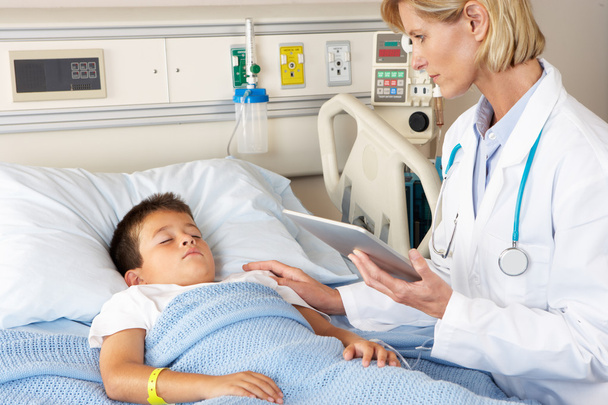 Doctor Using Digital Notepad Whilst Visiting Child Patient - Photo, Image