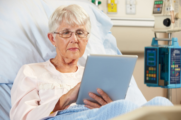 Senior Female Patient Relaxing In Hospital Bed With Digital Tabl - Фото, изображение