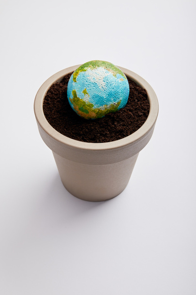planet model placed on flowerpot with soil, earth day concept - Foto, immagini