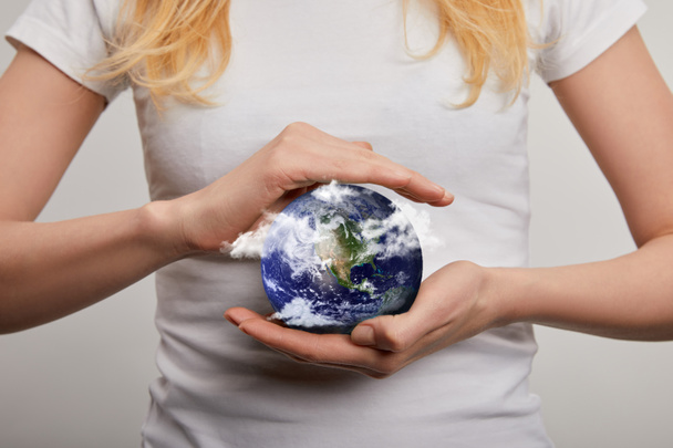 Frau mit Planetenmodell auf grauem Hintergrund, Earth Day Konzept - Foto, Bild