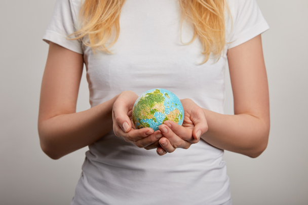 woman holding planet model on grey background, earth day concept - Photo, image