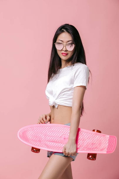 beautiful asian woman in sunglasses with skateboard - Foto, Imagem