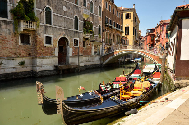 Gondola on Canal Grande. Gondolas moored on canal. Gondola service tourist people travel around Venice in Italy - Фото, зображення