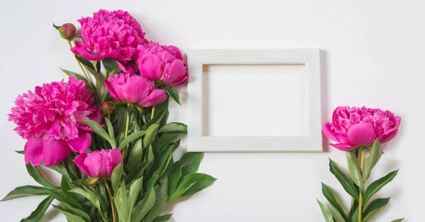 Bouquet of beautiful pink peony flowers and white frame for text on white. Copy space. Top view. Flat lay. - Foto, Bild