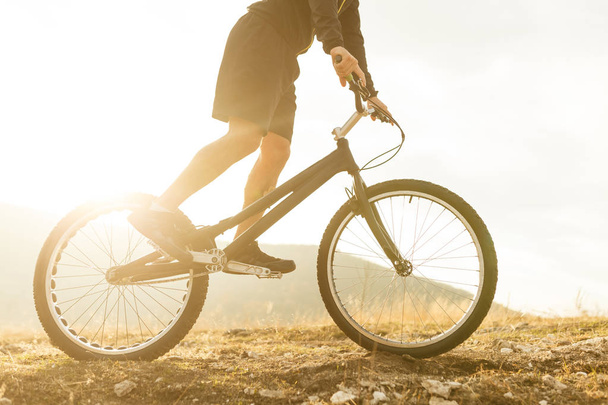 Crop guy riding bicycle in countryside - Valokuva, kuva